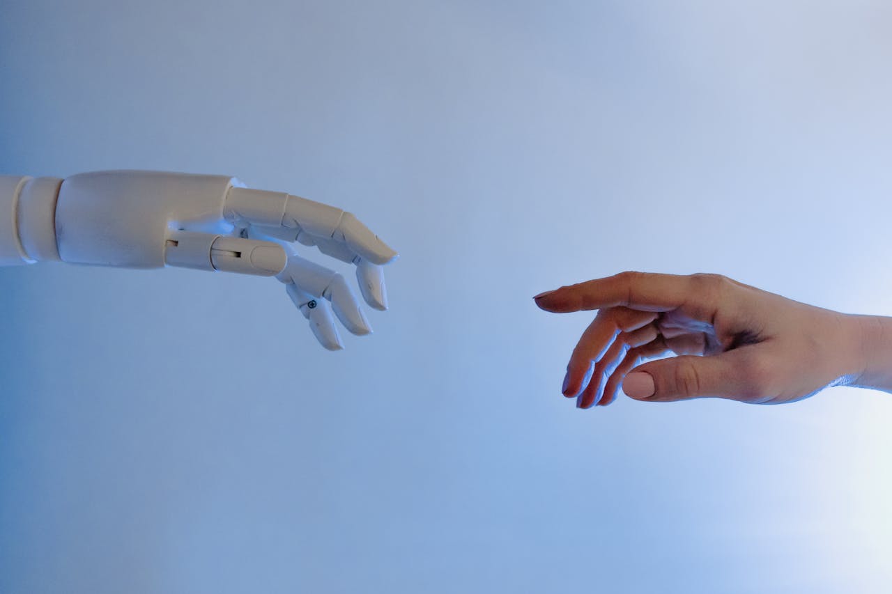A human hand reaching towards a robotic hand symbolizing technology and connection.